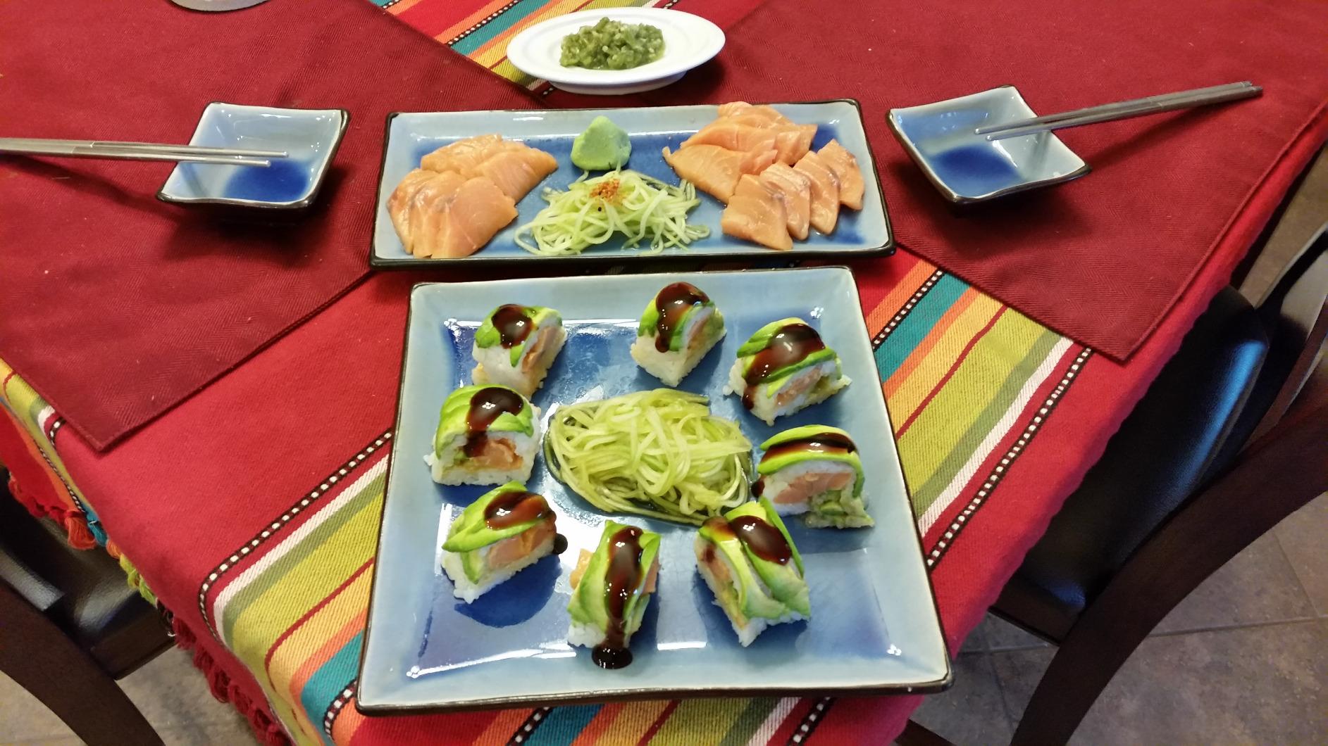 Salmon sashimi and avocado-topped sushi plated with nests of fine cucumber julienne cut on a Benriner